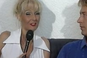 Sandra Foxxx interviewt mit Reporter. Die geile Brünette zieht sich aus und sitzt auf dem Sofa. Der Reporter massiert ihre Titten, sie drückt den Dildo in nasse Muschi. 